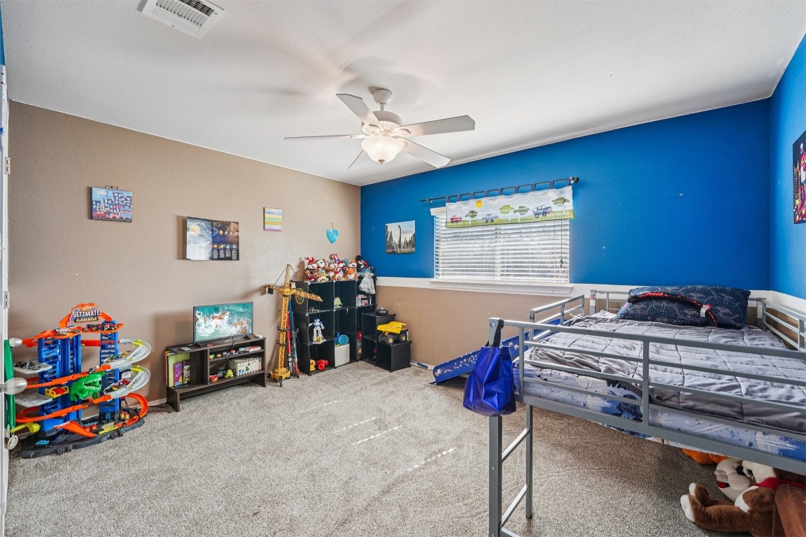 2301 Ambling Trail Pflugerville, TX 78660 - Photo 19 of 34 a bedroom with bed and a chandelier