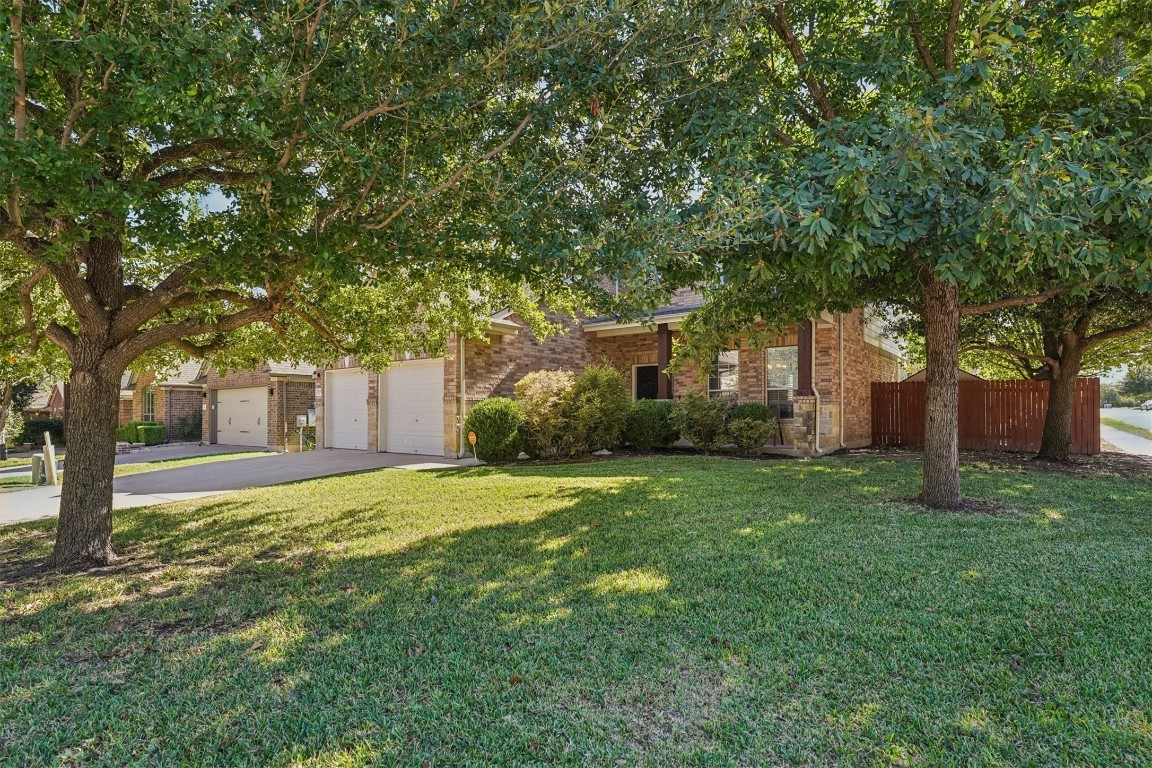 2301 Ambling Trail Pflugerville, TX 78660 - Photo 3 of 34 a front view of a house with a garden and trees