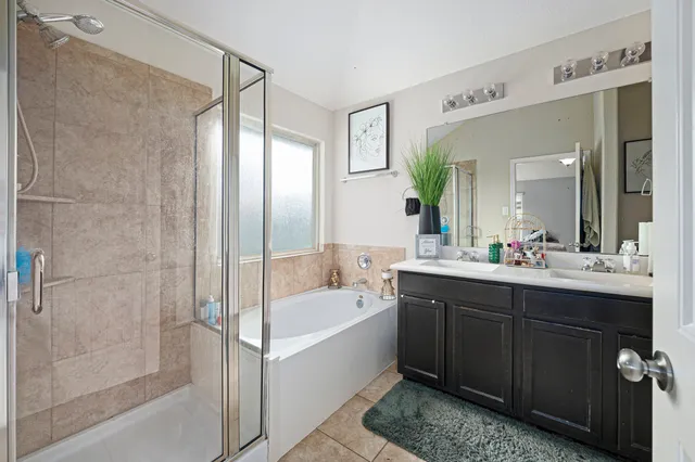 a bathroom with a tub sink shower and mirror