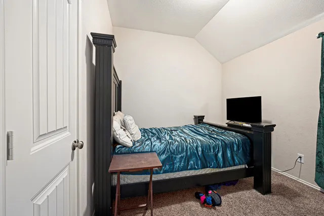 a bedroom with a bed window and a flat screen tv