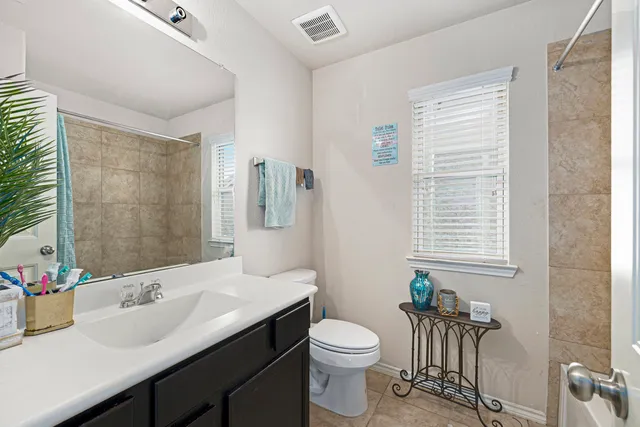 a bathroom with a sink vanity mirror and toilet