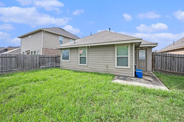 a view of a house with a yard and wooden fence