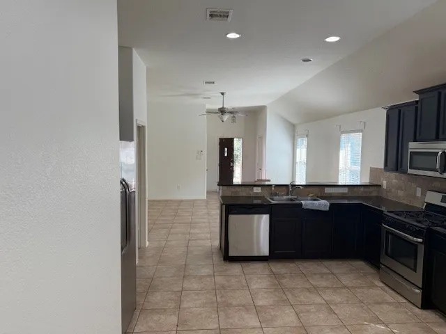 a large kitchen with granite countertop a sink and cabinets