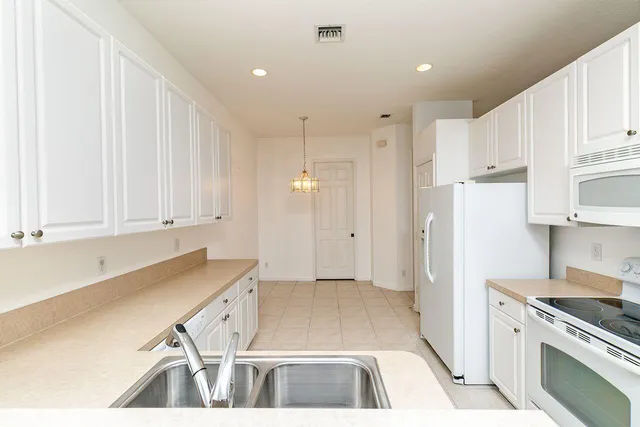 a kitchen with white cabinets and a sink