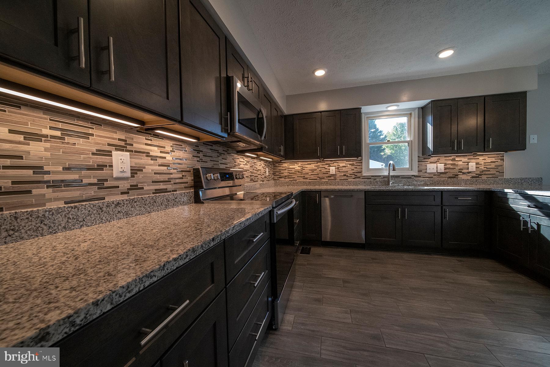 345 Edgewood Road Linthicum Heights, MD 21090 - Photo 11 of 63 a kitchen with stainless steel appliances granite countertop a sink counter space cabinets and a large window