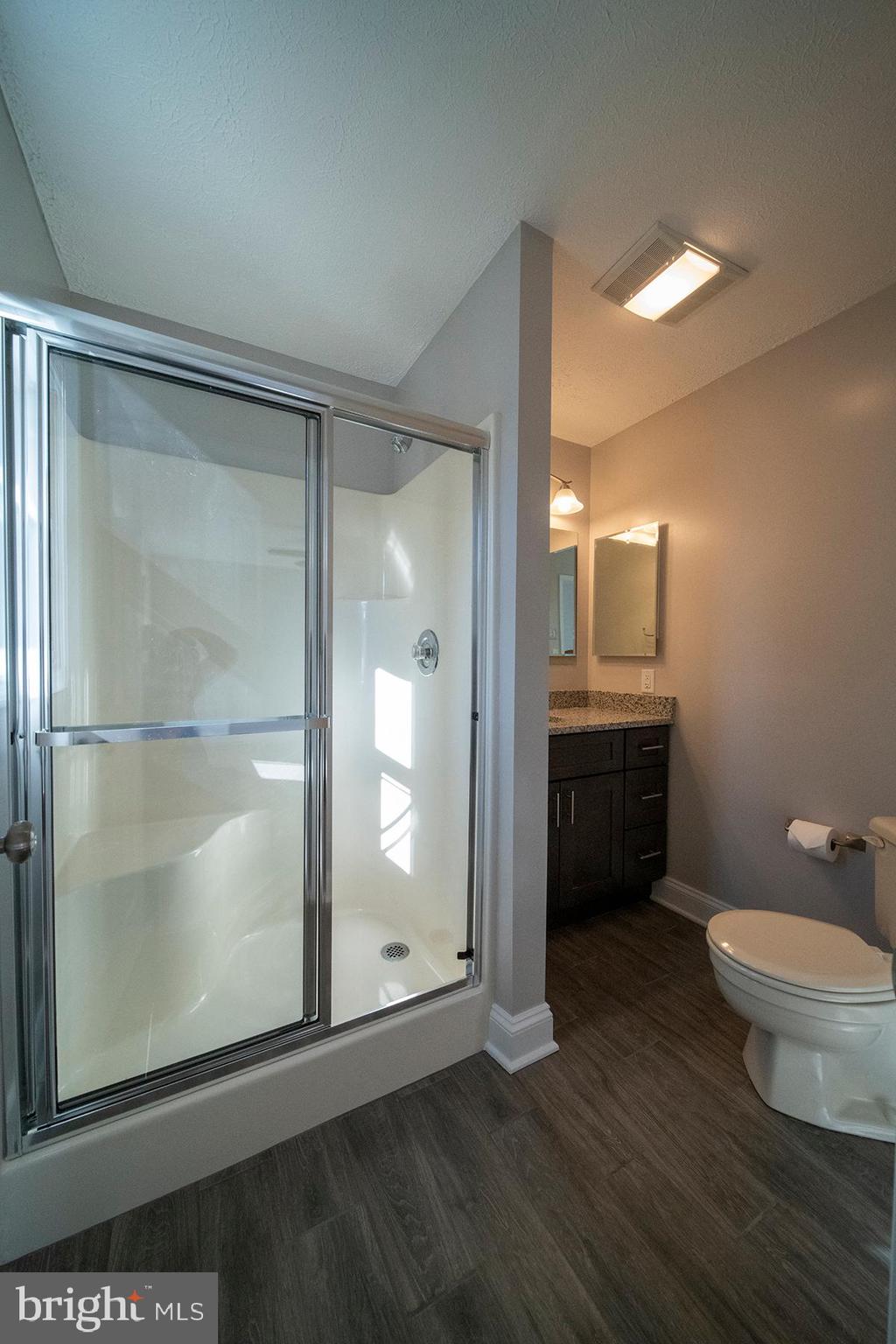 345 Edgewood Road Linthicum Heights, MD 21090 - Photo 38 of 63 a bathroom with a toilet a sink and glass door