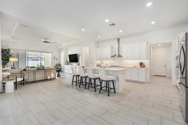 a living room with furniture a flat screen tv and kitchen view