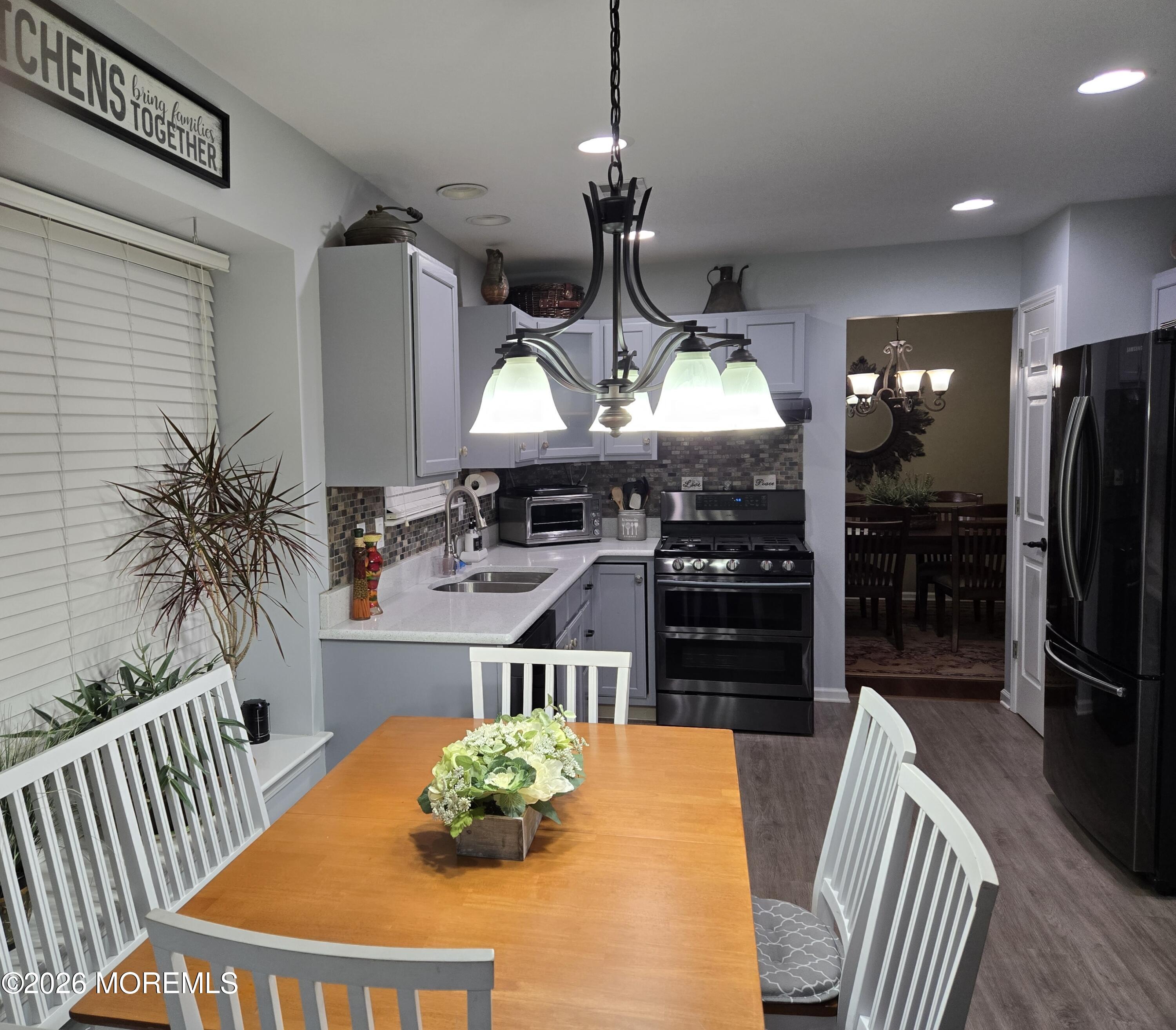 3276 Springer Lane Toms River, NJ 08755 - Photo 7 of 29 a kitchen with stainless steel appliances wooden floor dining table and chairs