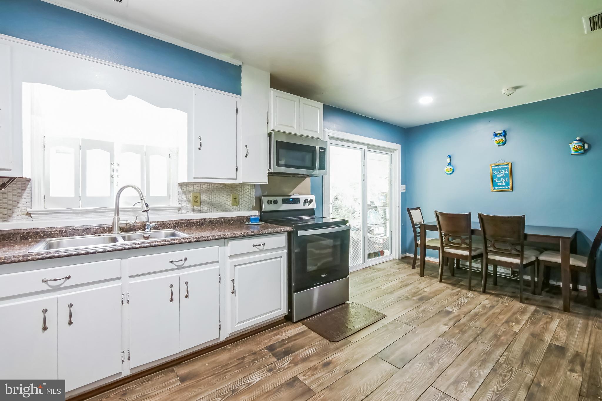 323 Russelcroft Road Winchester, VA 22601 - Photo 5 of 40 a kitchen with granite countertop a stove a sink a dining table and chairs