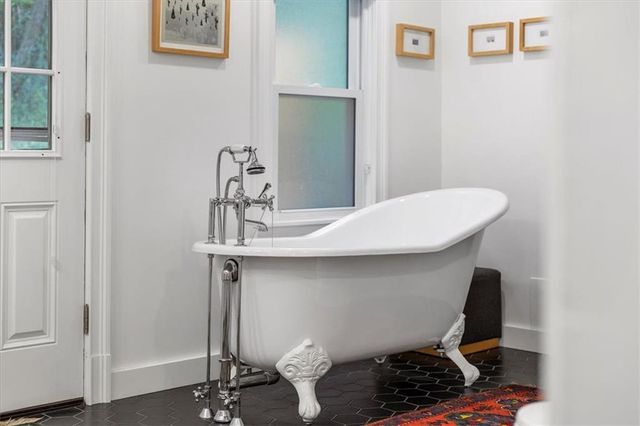 a bathroom with a bathtub and next to a window