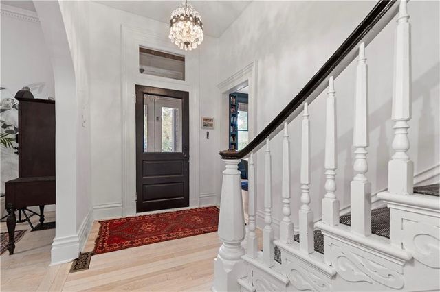 a view of a hallway with wooden floor and staircase