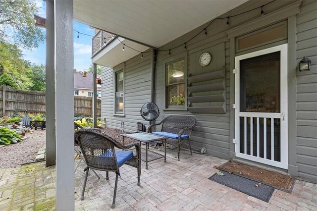 a view of a backyard with chairs and flower plants
