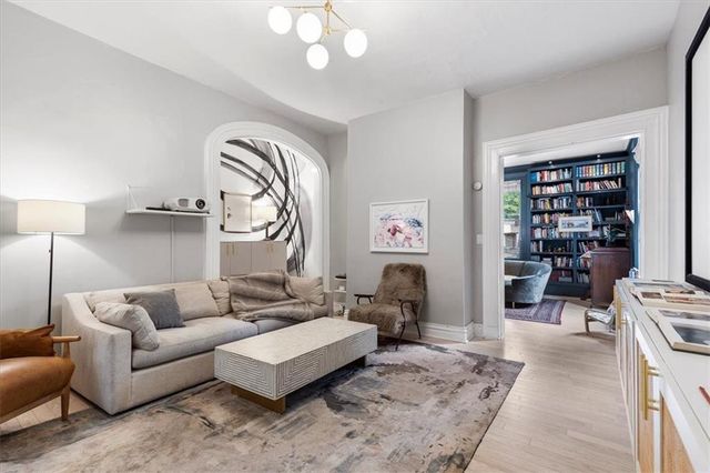 a living room with furniture a rug and a bookshelf