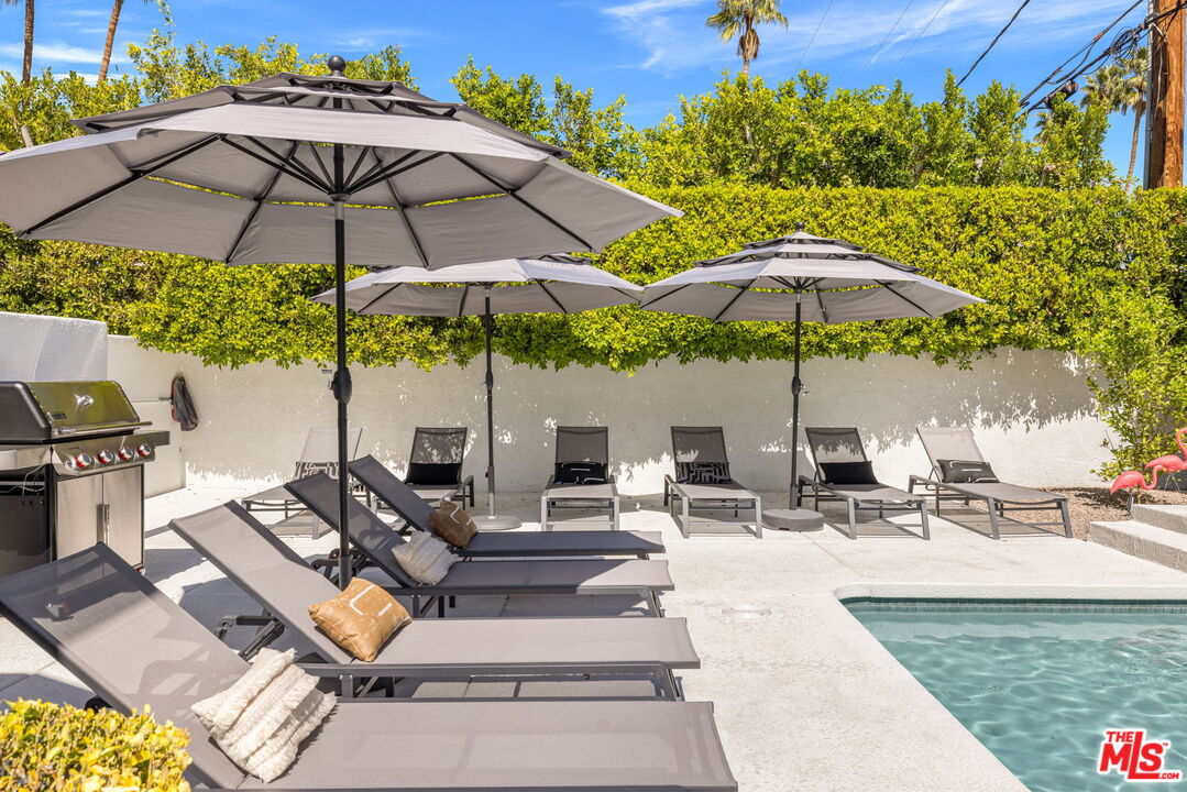 1414 Sagebrush Road Palm Springs, CA 92264 - Photo 43 of 48 a view of the patio with chairs and a umbrella