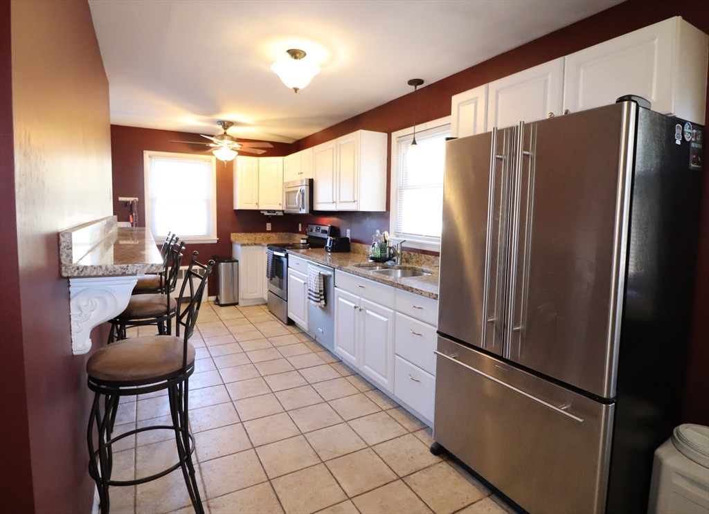 36 Stony Brook Road Raynham, MA 02767 - Photo 9 of 30 a kitchen with stainless steel appliances a refrigerator a stove a sink and chairs