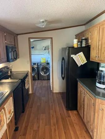 a kitchen with granite countertop a sink cabinets and wooden floor