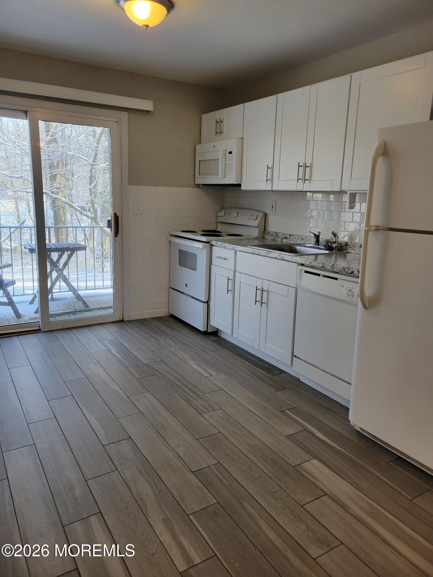 400 Matawan Avenue, Unit 57B Cliffwood, NJ 07721 - Photo 3 of 7 a kitchen with stainless steel appliances granite countertop a stove a sink and white cabinets