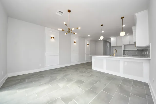 a view of a kitchen with a sink and chandelier