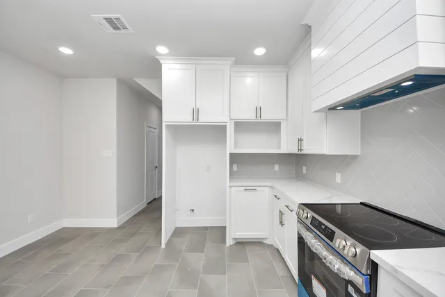 a kitchen with a sink a stove and cabinets