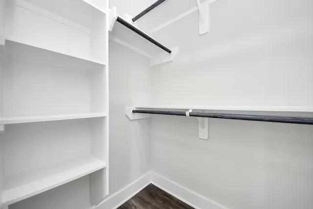 an empty room with wooden floor and window