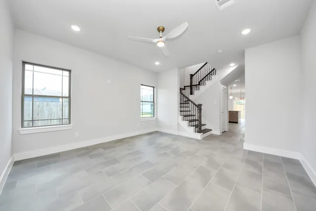 an empty room with stairs and windows