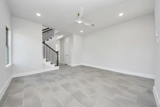 an empty room with staircase and white walls