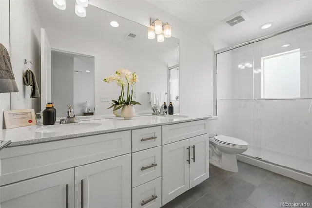 a bathroom with a double vanity sink and a toilet
