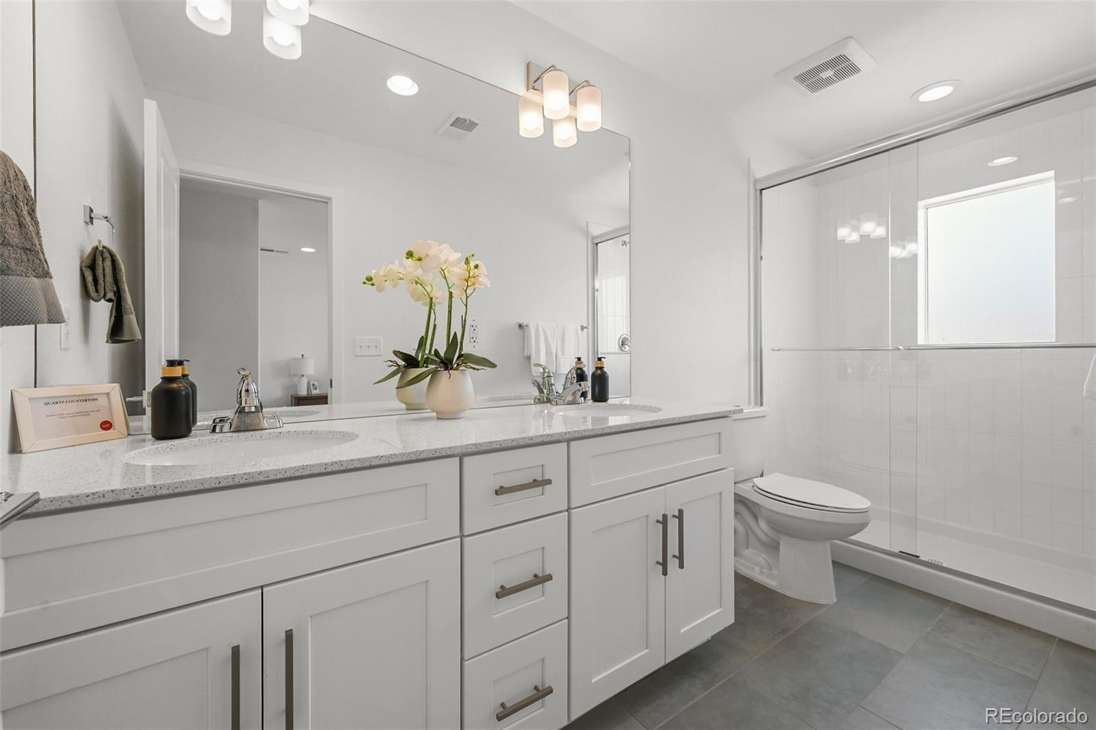 1314 Akron Street Aurora, CO 80010 - Photo 24 of 29 a bathroom with a double vanity sink and a toilet