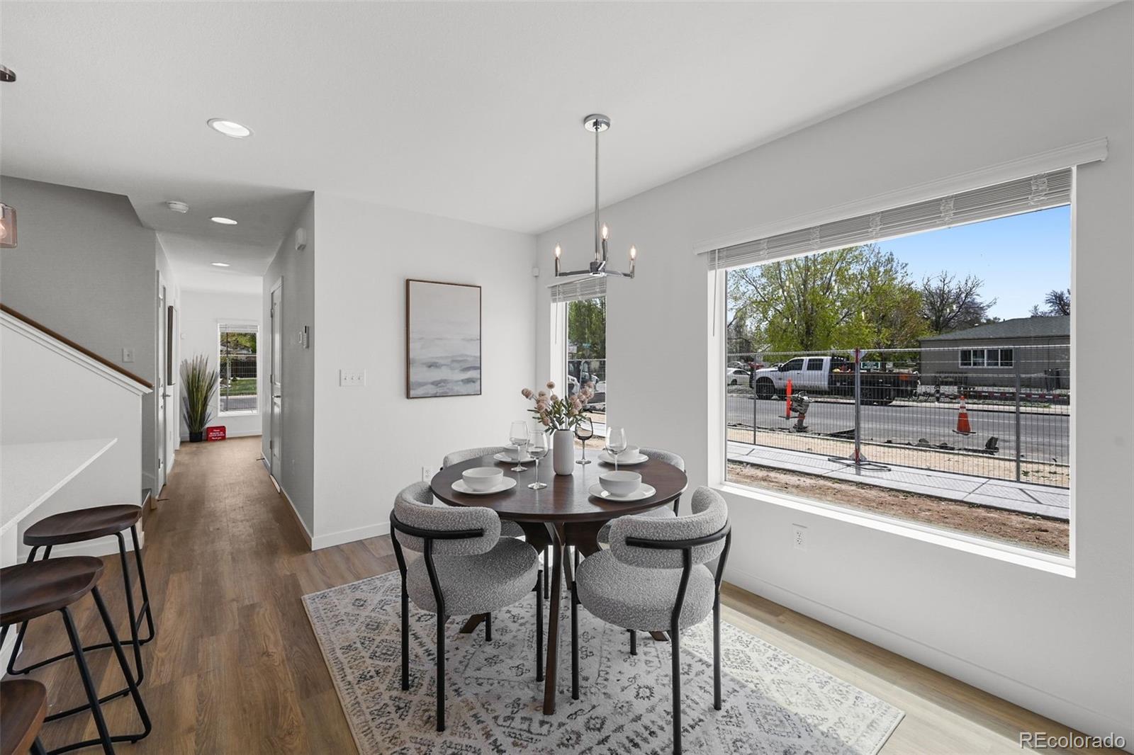 1314 Akron Street Aurora, CO 80010 - Photo 8 of 29 a dining room with furniture a chandelier and wooden floor
