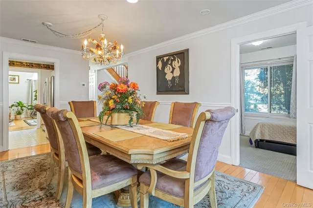 a view of a dining room with furniture a chandelier and wooden floor