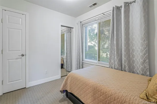 a bed sitting in a bedroom next to a window