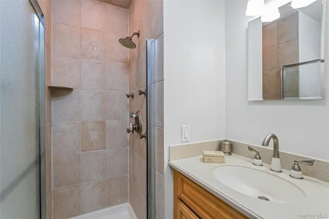 a bathroom with a sink shower and a mirror
