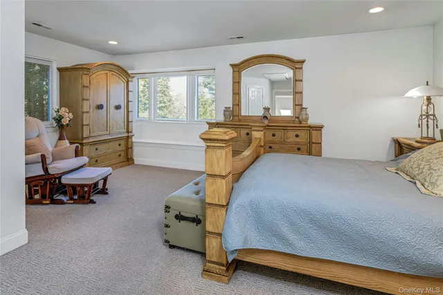 a bedroom with furniture and a large window