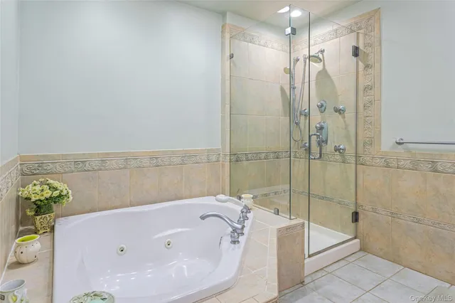 a bathroom with a white bath tub sitting next to shower