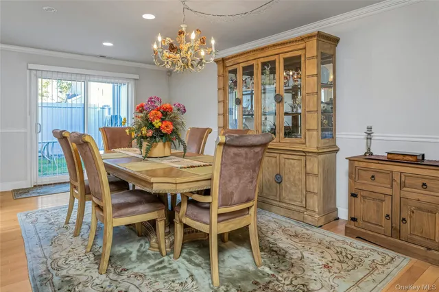 a dining room with furniture a chandelier and wooden floor