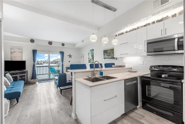 a kitchen with stainless steel appliances a stove a sink a microwave and cabinets