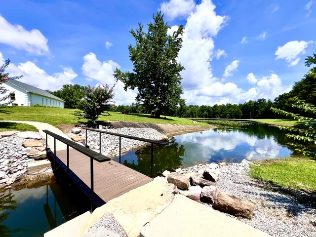 a view of a lake with a floor to ceiling window and wooden fence