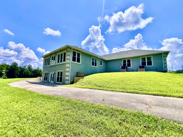 a front view of a house with yard and green space