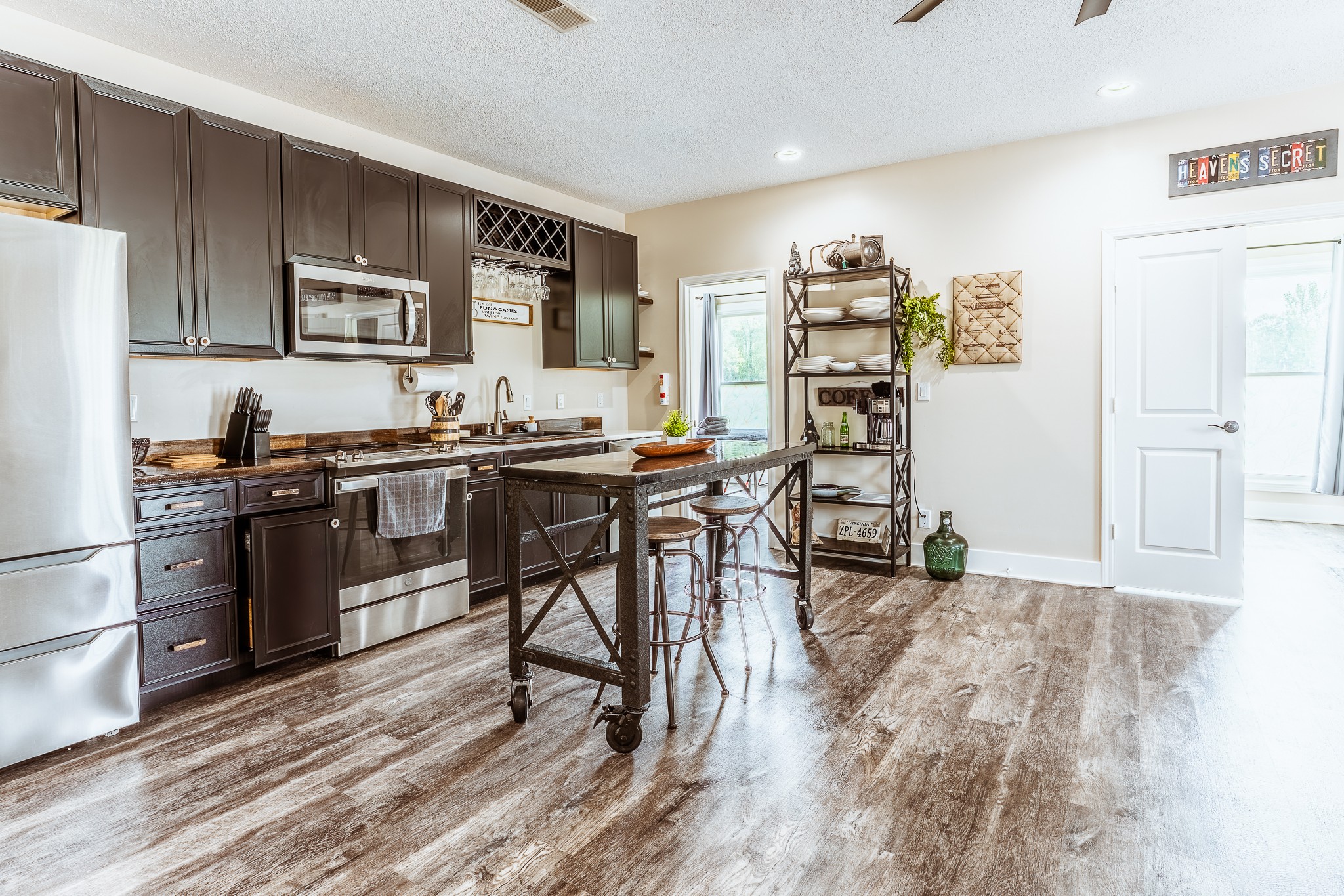 3375 Rowland Mill Road Buena Vista, TN 38318 - Photo 25 of 85 a kitchen with stainless steel appliances a stove a refrigerator a sink a dining table and chairs with wooden floor