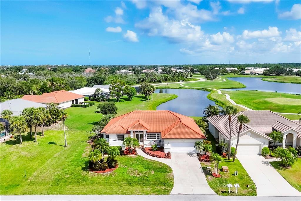 an aerial view of a house with a garden and lake view