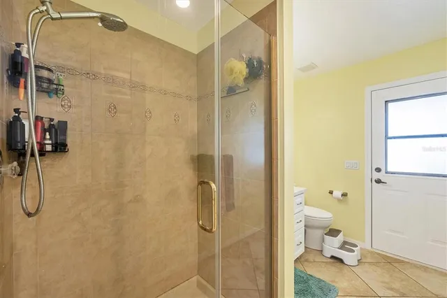 a bathroom with a granite countertop shower and a toilet
