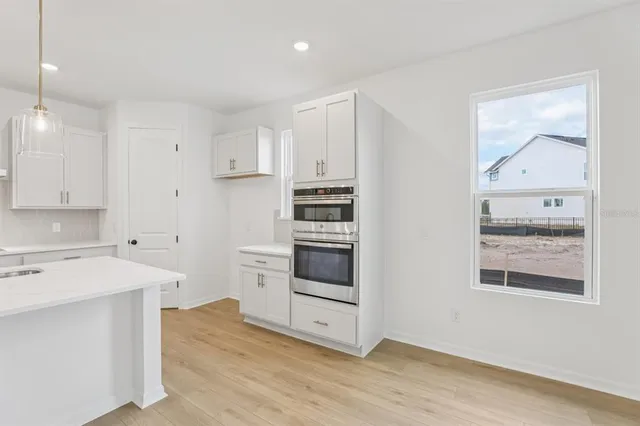 a kitchen with kitchen island a sink stainless steel appliances and cabinets