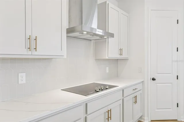 a large kitchen with kitchen island a stove a sink a center island and wooden floor