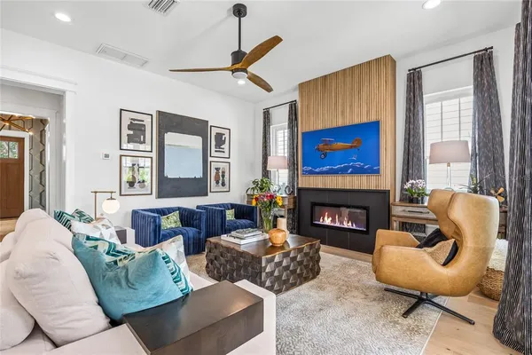 a living room with furniture a chandelier and a flat screen tv