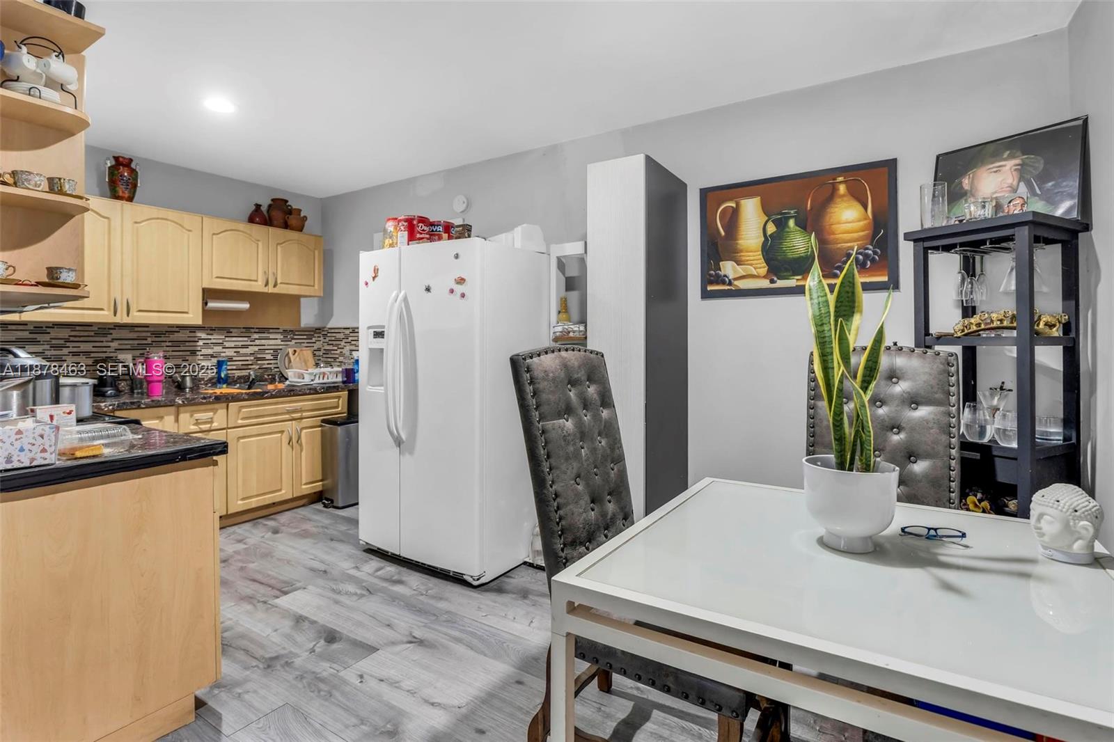580 Southeast 2nd Street Hialeah, FL 33010 - Photo 8 of 30 a kitchen with a refrigerator a stove a sink dishwasher a dining table and chairs with wooden floor