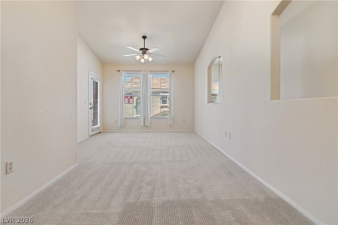 10550 West Alexander Road, Unit 2060 Las Vegas, NV 89129 - Photo 12 of 45 Well-lit living area with vaulted ceilings and plush carpeting, perfect for quiet enjoyment.