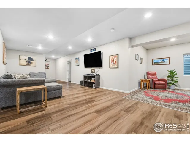 a living room with furniture a window and a wooden floor