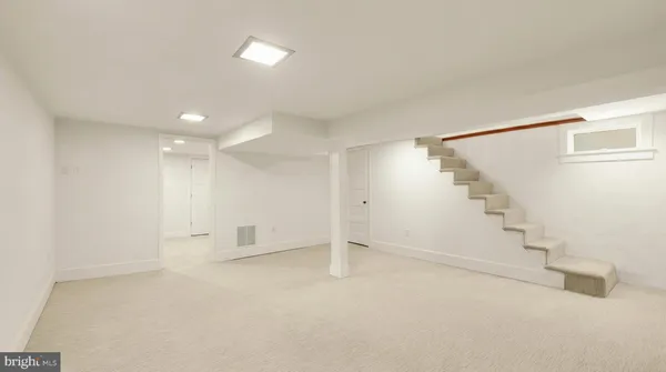 a view of an empty room with stairs and a hallway
