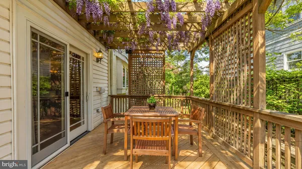 a patio with table and chairs and potted plants