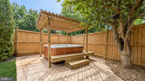 a view of a backyard with a large tree and wooden fence